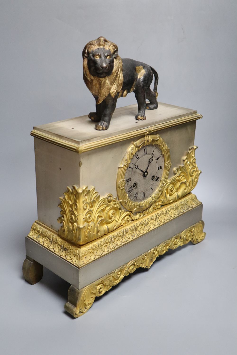 A French gilt and silvered mantel clock, with associated lion surmount, height 40cm